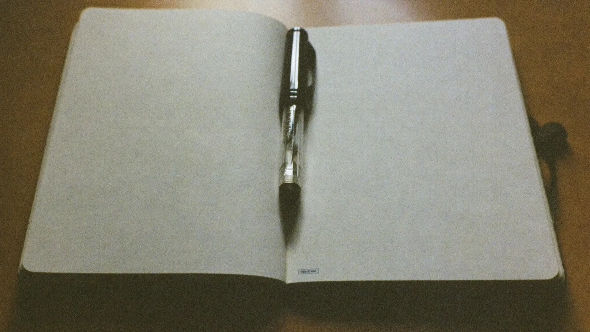 Retro filmfoto av ett tomt anteckningsblock med en penna – planering och checklista.