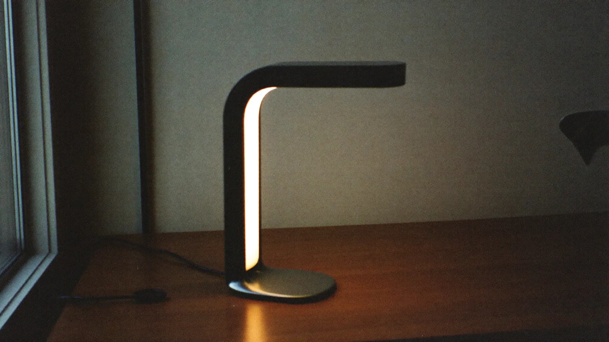 Retro filmfoto av en stilren designlampa som lyser varmt – premium och avancerat.