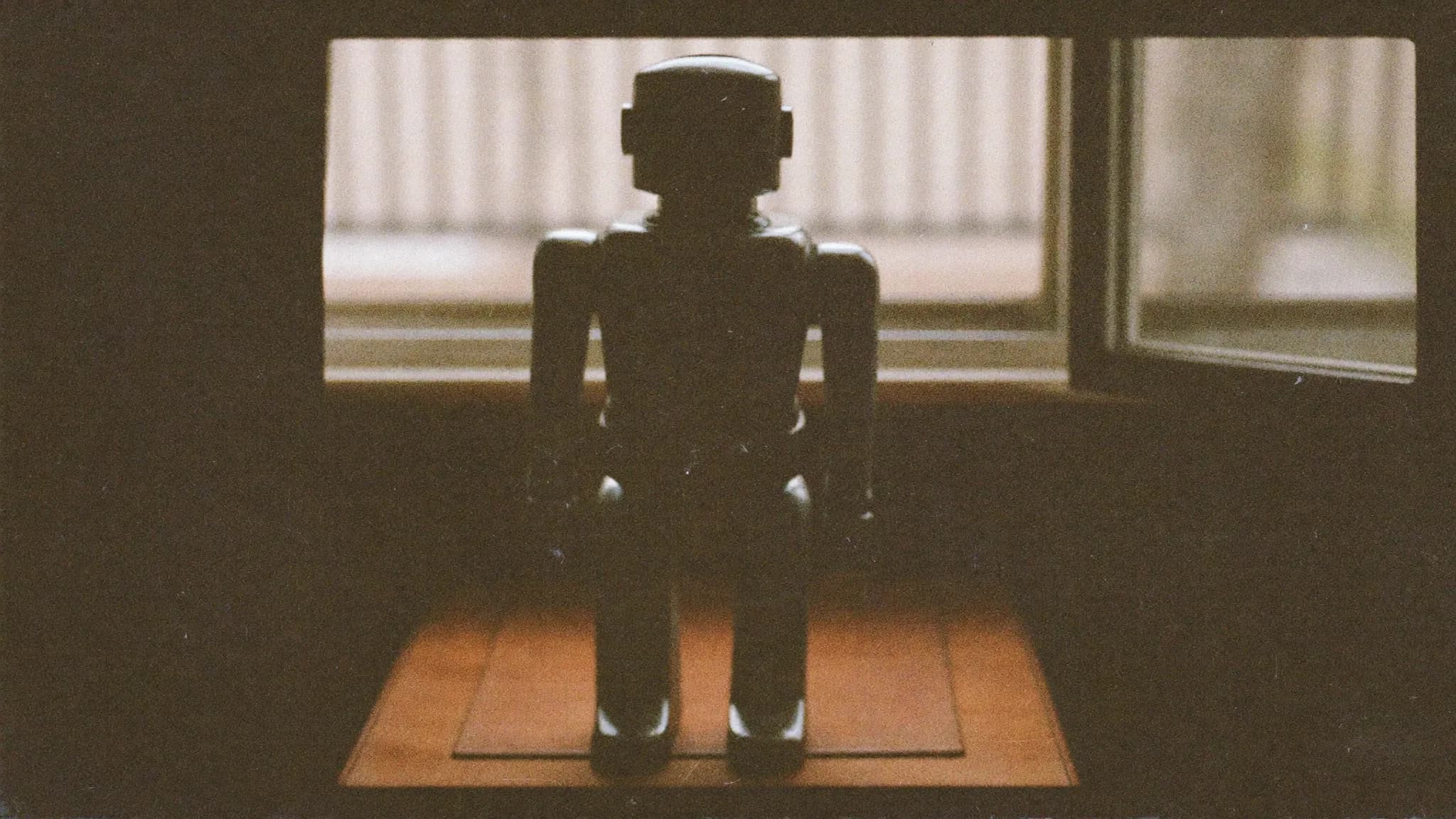 Retro filmfoto av en gammal leksaksrobot på ett skrivbord – AI och digital synlighet.